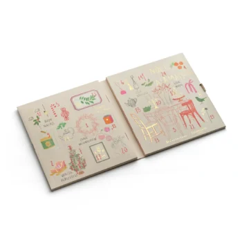 Calendrier de l'Avent Dammann Frères ouvert avec ses vingt-quatre cases numérotées, illustré de motifs festifs dorés et colorés sur fond beige