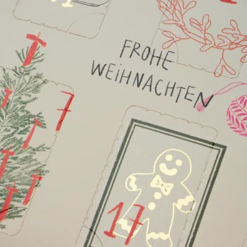Calendrier de l'avent avec inscription Frohe Weihnachten et case numéro 17 illustrée d'un petit bonhomme en pain d'épices doré