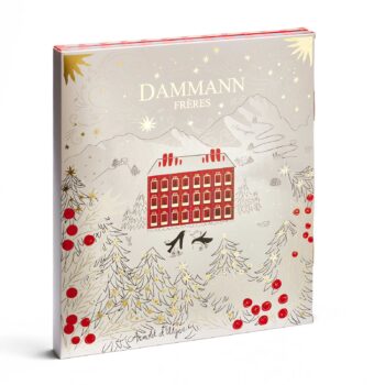 Calendrier de l'Avent Dammann Frères 2025 illustrant une maison rouge dans un paysage hivernal enneigé avec des sapins décorés de boules rouges et de guirlandes dorées