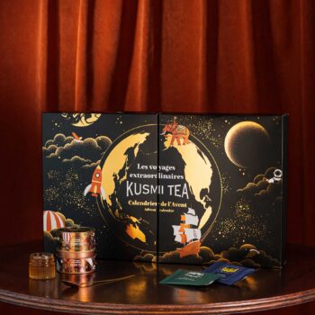 Calendrier de l'Avent Kusmi Tea avec un design de globe terrestre, fusée, éléphant et voilier, symbolisant un voyage extraordinaire.
