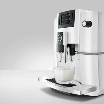 La JURA E6 Piano White (EB) prépare une mousse de lait
