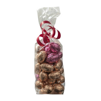 Sachet transparent rempli d'œufs de Pâques pralinés dorés et roses, fermé par un ruban rouge, format 250g