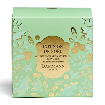 Boîte de tisane de Noël Dammann Frères, vert menthe avec des motifs dorés de feuilles et de baies, mettant en avant le nom "Infusion de Noël" et "Dammann Frères"