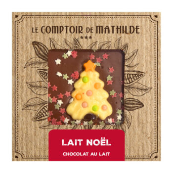 Tablette de chocolat au lait Le Comptoir de Mathilde avec un décor de sapin de Noël, garnie de vermicelles colorés et d'étoiles.