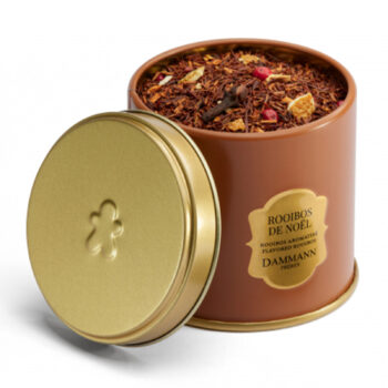Boîte métallique Dammann Frères ouverte, remplie de Rooibos de Noël aux notes d'orange, pain d'épices, gingembre, clou de girofle et baie rose.