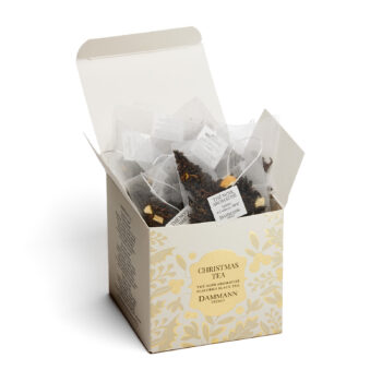 Boîte ouverte de 50g de sachets Cristal Dammann Frères Christmas Tea, thé noir aromatisé aux agrumes et caramel, décoration florale dorée