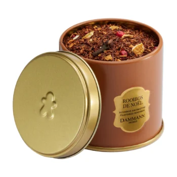 Boîte métallique de Rooibos de Noël Dammann Frères ouverte, dévoilant un mélange de thé avec des morceaux d'agrumes, des clous de girofle et des baies