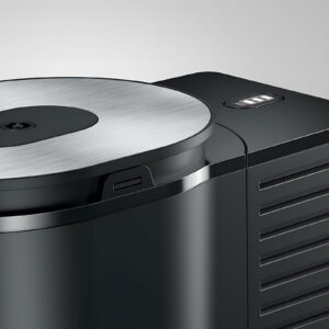Détail latéral du JURA Cool Control 1L (EB) Black, mettant en évidence son design noir mat élégant, ses lamelles de ventilation latérales et le logo chromé sur le côté.
