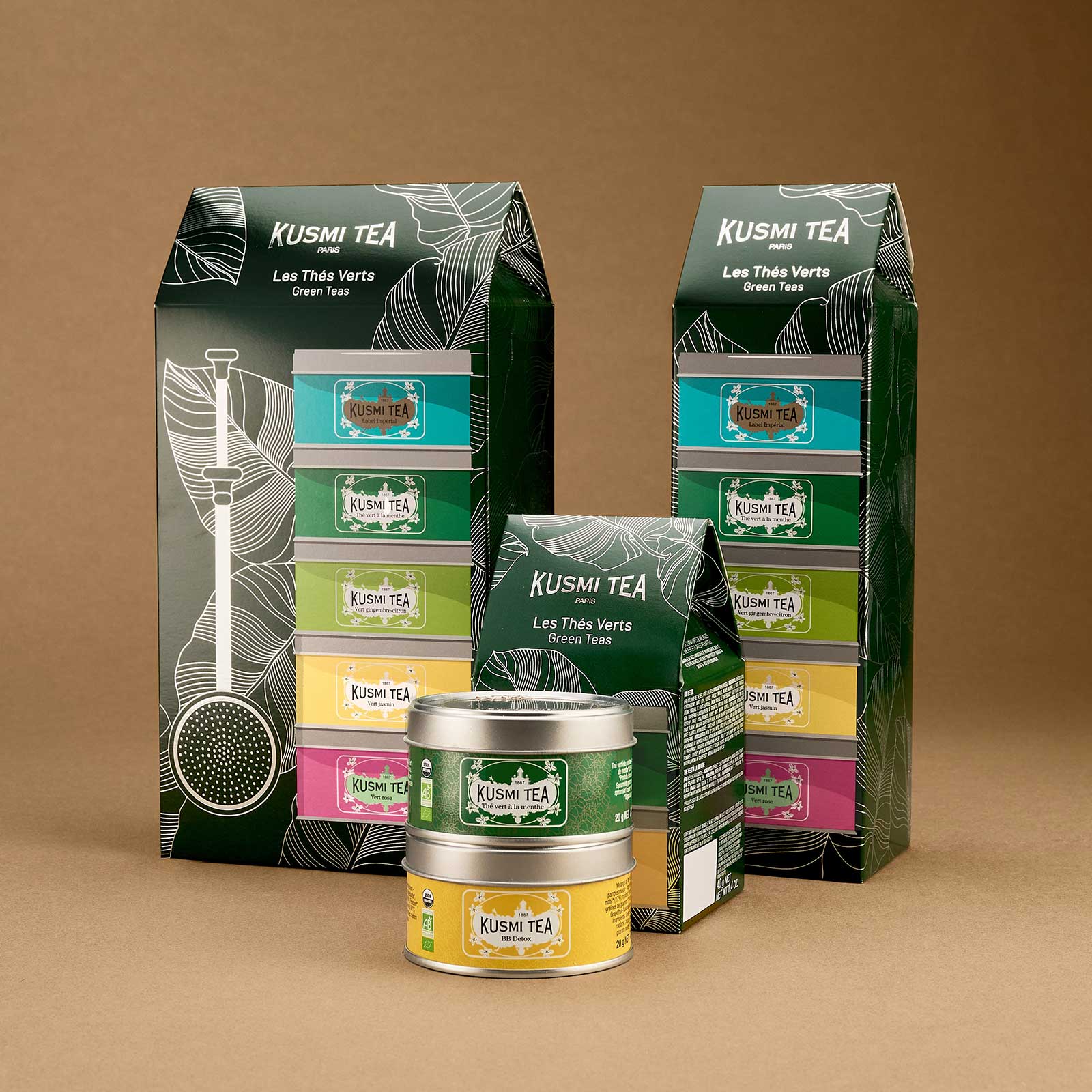 Coffret cadeau Kusmi Tea composé de boîtes de thé vert colorées et d'emballages en carton vert décorés de motifs tropicaux