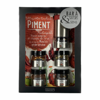 Emballage du Bar à Piments par Savor & Sens. L'emballage noir présente le texte 'Mettez votre touche de PIMENT' avec des instructions sur la rechargeabilité et l'utilisation du moulin à piment. À l'intérieur, on peut voir un moulin à piment en métal argenté avec plusieurs sections contenant différents types de piments comme les flocons de piment Pequin, New Mexico, Pasilla, Habanero et Jalapeño. Des illustrations artistiques de feuilles de piments rouges, de cactus et de fleurs ornent l'arrière-plan.