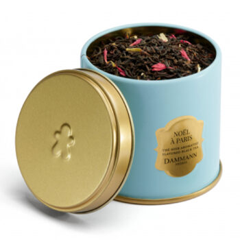 Boîte métal bleue Dammann Frères Noël à Paris 100g, ouverte, contenant du thé noir en vrac avec des pétales rouges et jaunes