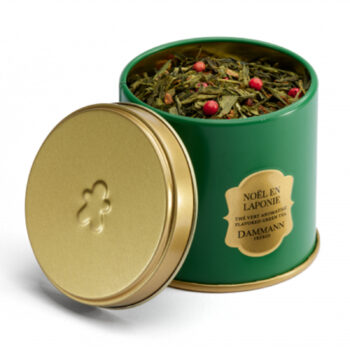 Boîte métallique verte Dammann Frères "Noël en Laponie" ouverte, remplie de thé vert aromatisé aux baies roses et morceaux de cannelle.