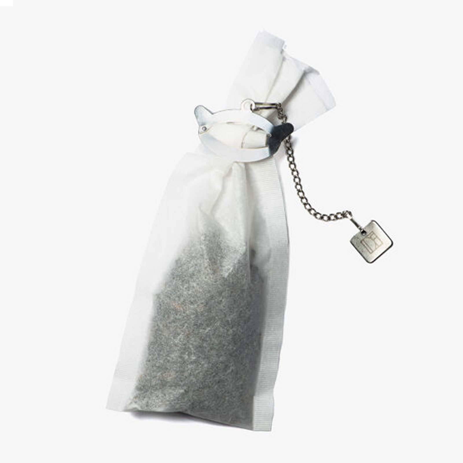 Filtre à thé compostable Dammann Frères rempli de thé en vrac, avec pince en inox en forme de théière et chaîne décorative