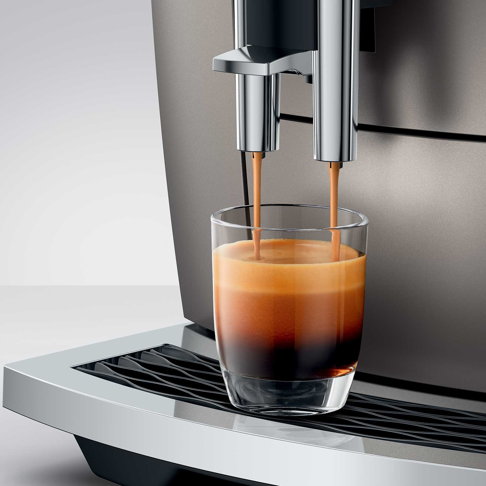 Machine à expresso JURA E8 Midnight Silver préparant un café espresso dans un verre transparent, crema onctueuse