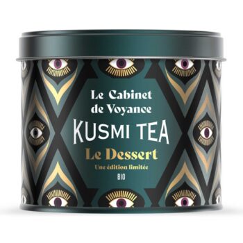 Boîte ronde Kusmi Tea Le Dessert en métal vert foncé et doré, motif géométrique aux yeux stylisés, mention BIO
