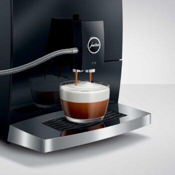 Machine à café JURA C9 Piano Black préparant un cappuccino avec deux jets de café et une mousse de lait onctueuse dans un verre
