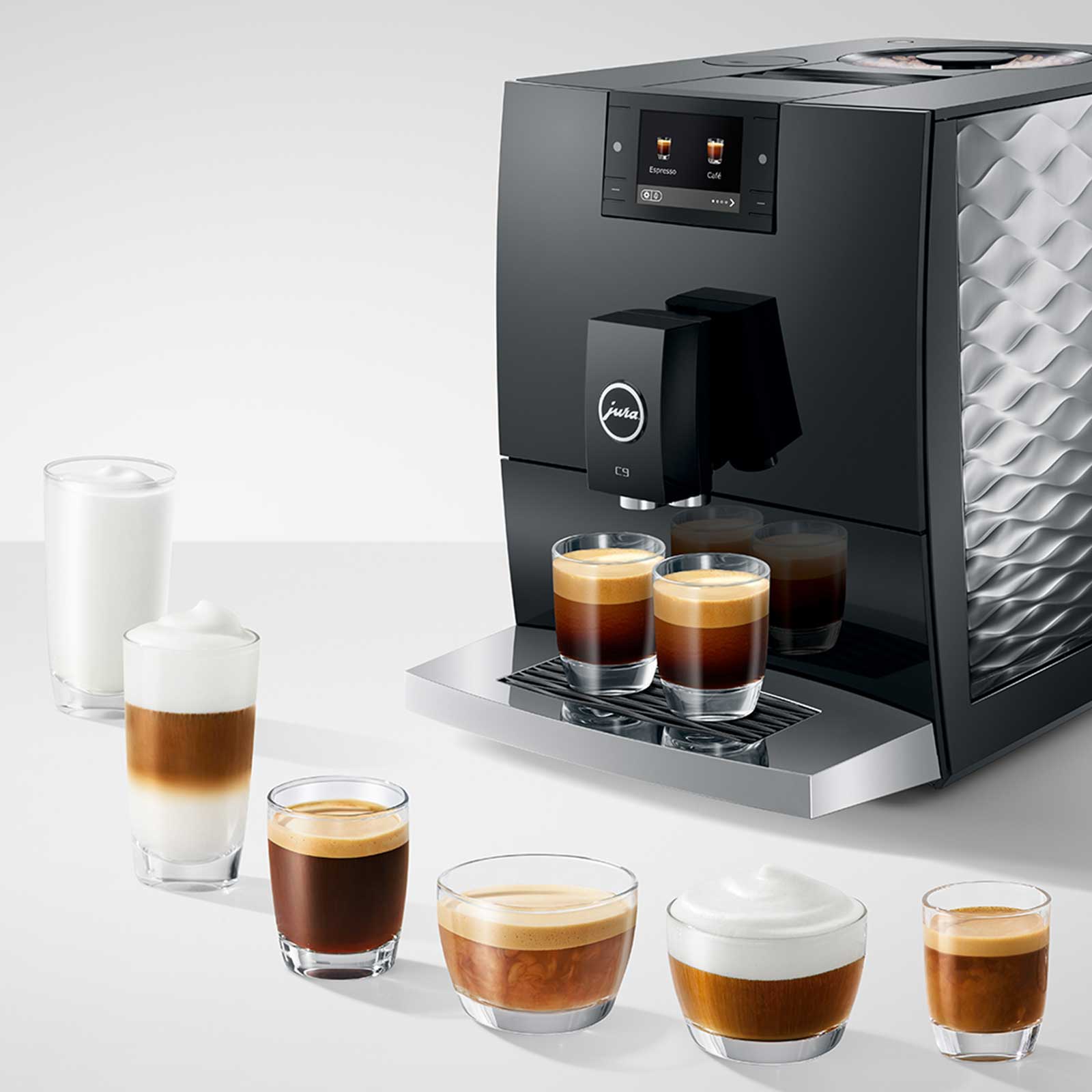Machine à café automatique Jura C9 Piano Black avec 7 tasses de café préparées de différentes tailles et types, dont un cappuccino et un espresso.