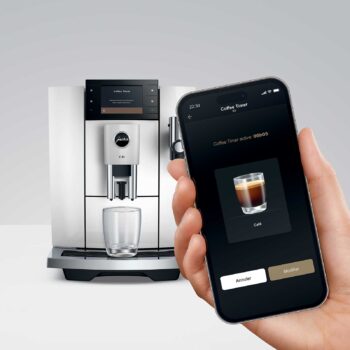 Machine à café JURA E8 Piano White avec un smartphone affichant l'application Coffee Timer, contrôlant la préparation du café.