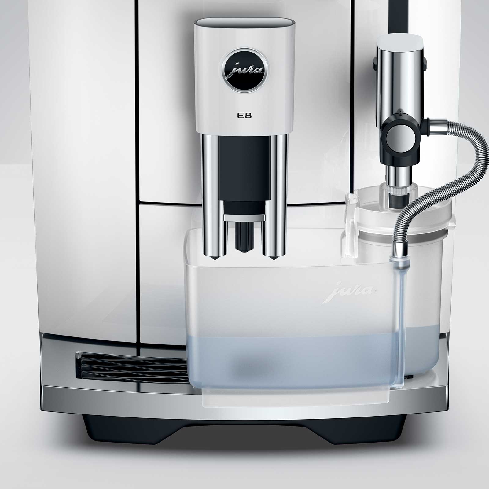 Machine à café JURA E8 Piano White avec réservoir d'eau transparent rempli, détail du bec verseur et de la buse vapeur