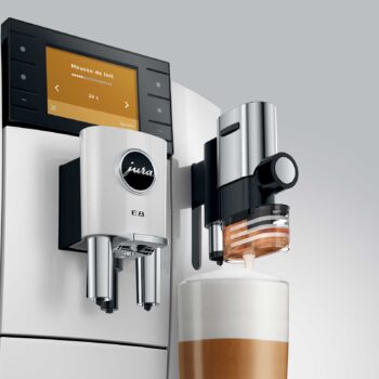 Machine à café JURA E8 Piano White préparant une mousse de lait, avec écran affichant 'Mousse de lait' et le logo Jura.