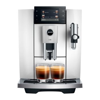 Machine à café automatique JURA E8 Piano White avec deux verres d'espresso fraîchement préparé en premier plan, écran tactile affichant les options de café