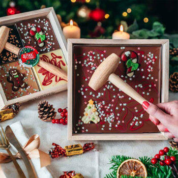 Tablette de chocolat de Pâques à casser, décorée de bonhomme en pain d'épice, sucre d'orge et sapin, avec petit maillet en bois.
