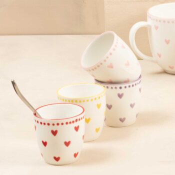 Quatre gobelets en porcelaine de la collection Love, ornés de cœurs colorés et de points, dont un avec une cuillère