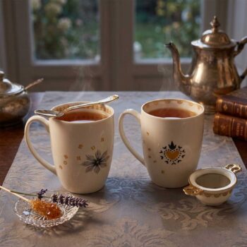 Ensemble de vaisselle en porcelaine blanche avec motifs dorés et bleu nuit, incluant des tasses, des soucoupes et des bols, disposés sur une nappe décorée