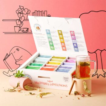 Coffret ouvert 'Histoire d'infusions' des 2 Marmottes, présentant 15 variétés de sachets colorés, avec une tasse d'infusion ambrée à côté
