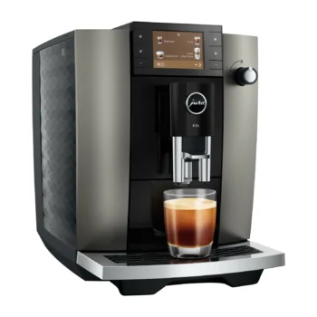 Machine à expresso automatique Jura E6 gris anthracite avec écran tactile et tasse en verre remplie de café fraîchement extrait