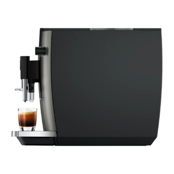 Machine à expresso automatique noire et argentée distribuant un café dans un verre transparent posé sur son plateau en métal