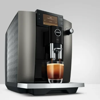 Gros plan sur l'écran numérique d'une machine à café Jura E6 affichant le réglage Coffee Timer pour un café programmé à 6h30