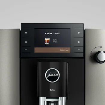 Gros plan sur l'écran numérique d'une machine à café Jura E6 affichant le réglage Coffee Timer pour un café programmé à 6h30