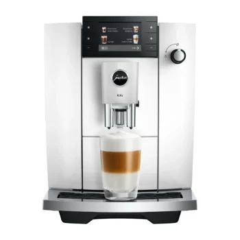 Machine à café automatique Jura E6 blanche avec écran tactile et verre de latte macchiato préparé sur le repose-tasse