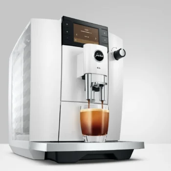 Machine à café automatique Jura E6 blanche en fonctionnement, préparant un café noir dans un verre sur le plateau égouttoir