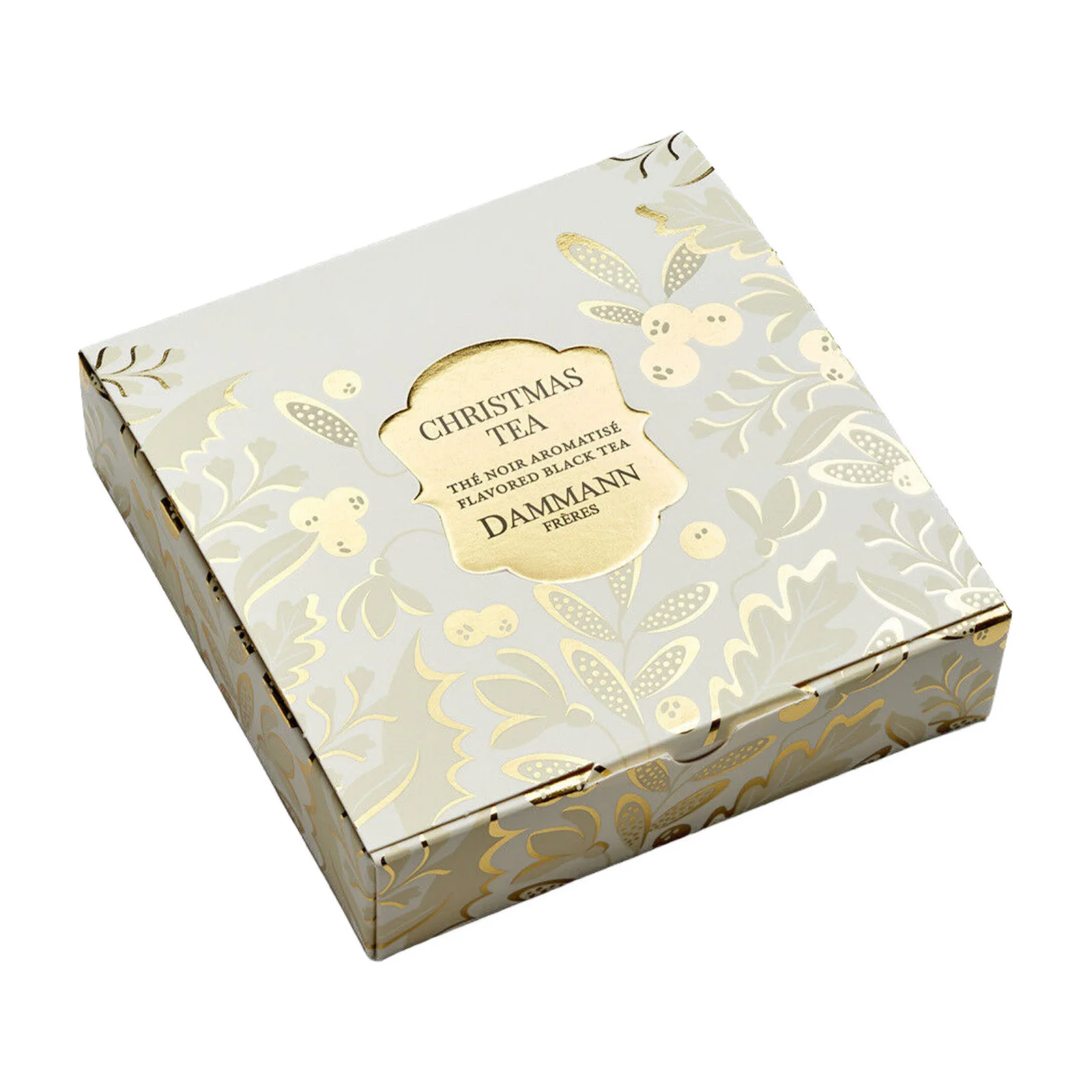 Boîte carrée de Christmas Tea Dammann Frères avec des motifs de feuilles et de baies dorées sur fond blanc cassé, présentée en vue en plongée