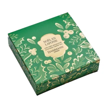 Boîte de thé vert aromatisé Noël en Laponie Dammann Frères, packaging vert orné de motifs végétaux dorés et de baies