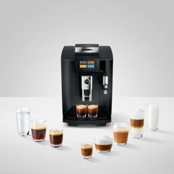Machine à expresso automatique Jura E8 noire entourée de diverses boissons au café et verres d'eau sur un fond blanc épuré