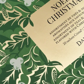 Détail du packaging en carton vert orné de motifs végétaux dorés pour l'assortiment de thés de Noël de la maison Dammann Frères