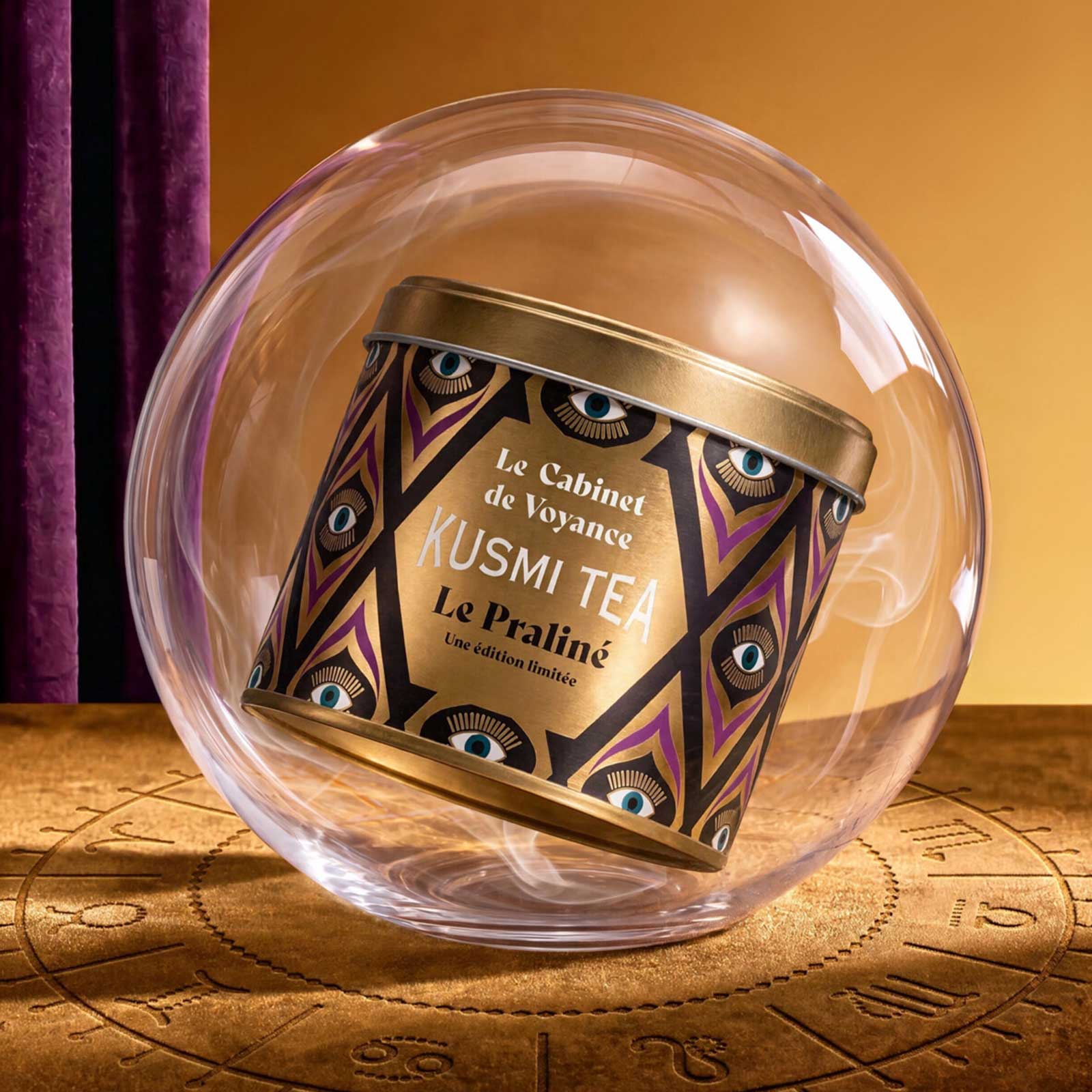 Boîte de thé Kusmi Tea Le Praliné de l'édition limitée Le Cabinet de Voyance suspendue dans une sphère de verre au-dessus d'une carte astrale